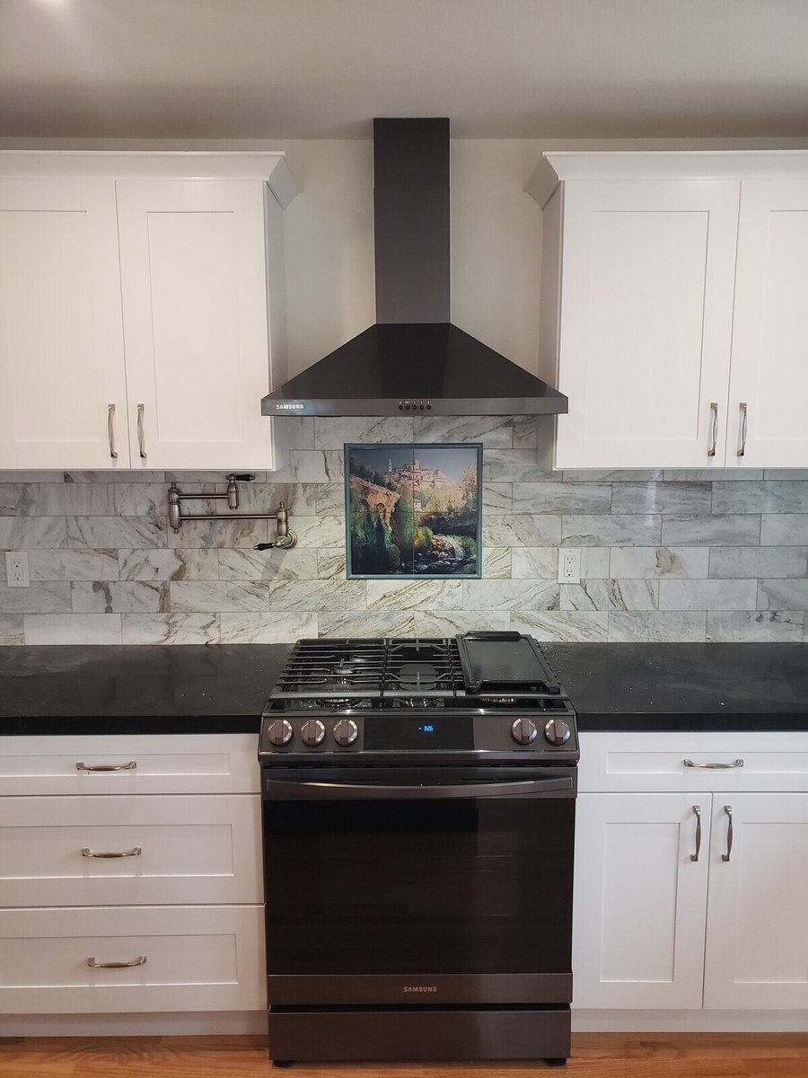 Modern kitchen remodel with white cabinets, black countertops, and a stainless steel hood by H&H Builds in Sacramento, CA