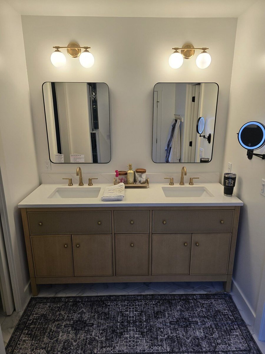 Modern bathroom remodel showcasing a double sink vanity with gold hardware and mirrors by H&H Builds, Sacramento