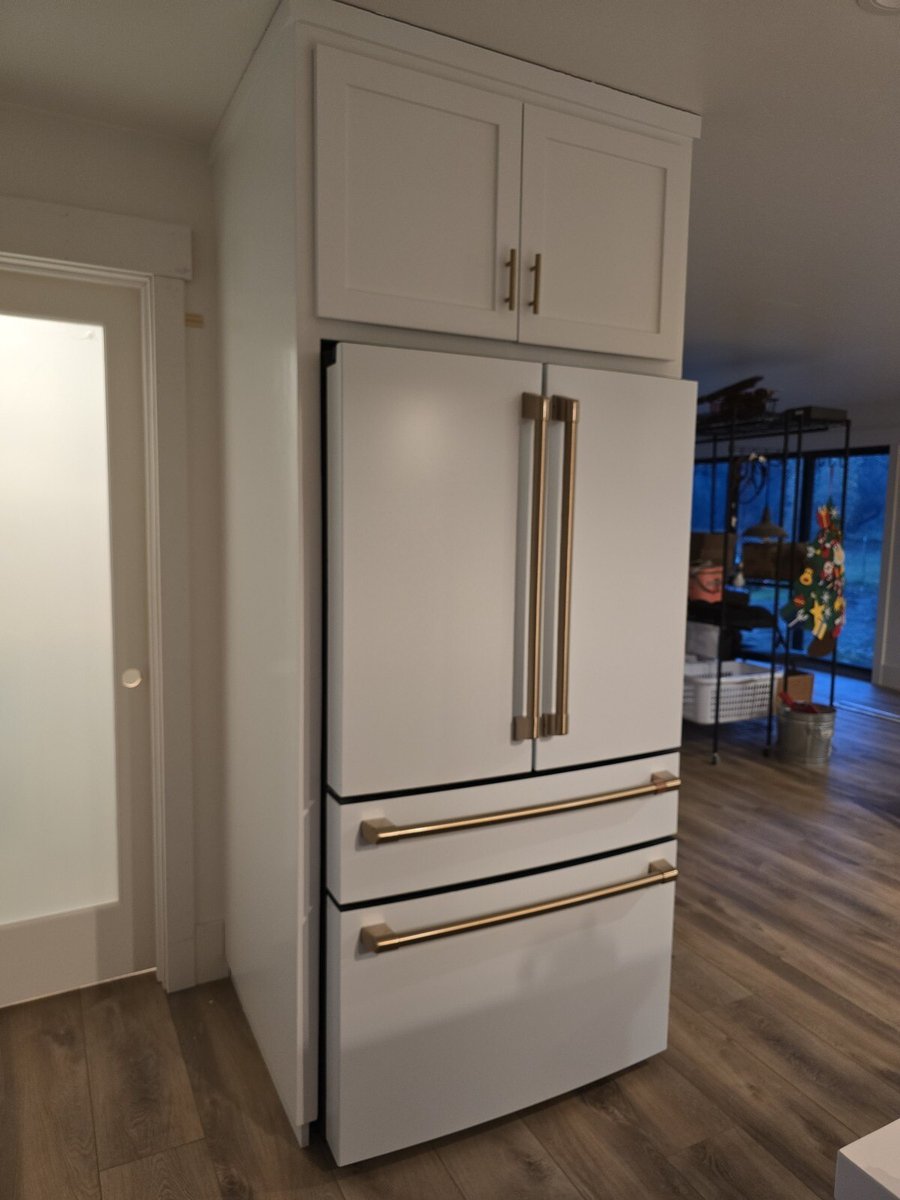 Stylish white refrigerator with gold handles in a modern kitchen remodel by H&H Builds in Sacramento, CA